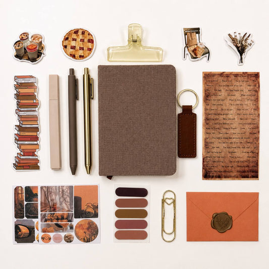 Collection of stationery items including a notebook, pens, clips, and other office supplies on a white background.