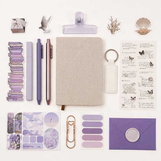 Collection of stationery items including a notebook, pens, stickers, and clips on a white background