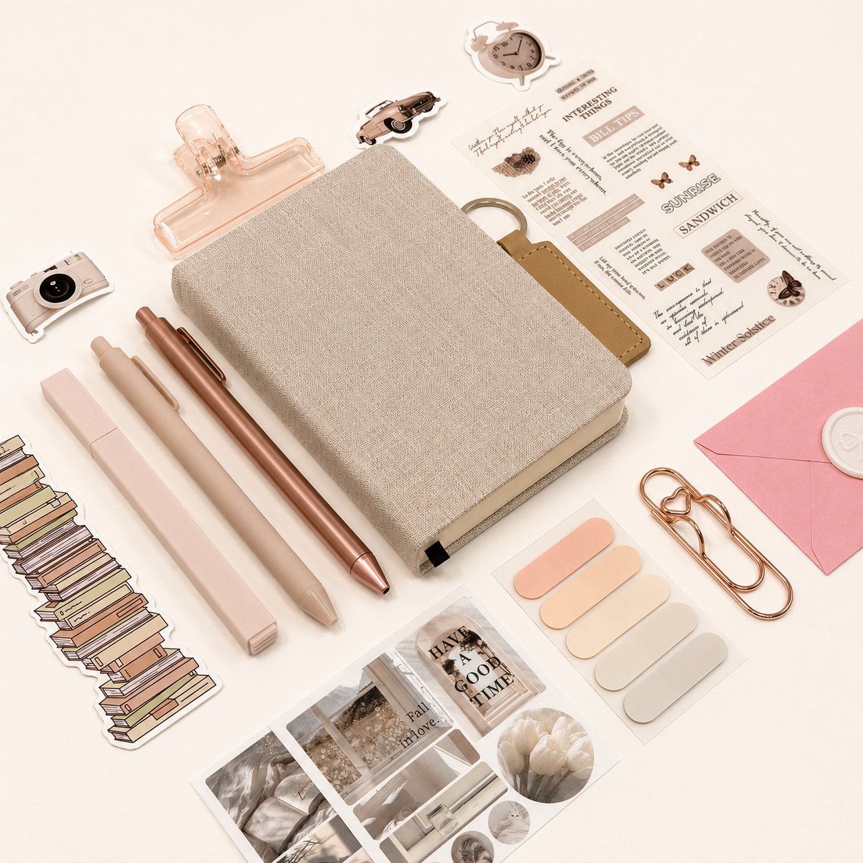 Collection of stationery items including pens, a notebook, and decorative elements on a white background