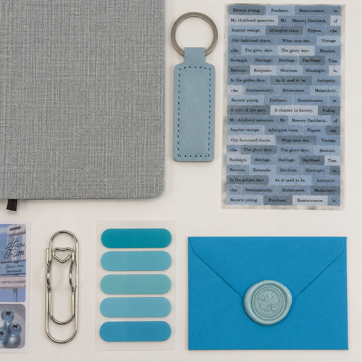 Collection of stationery items including a notebook, keychain, and envelope on a white background
