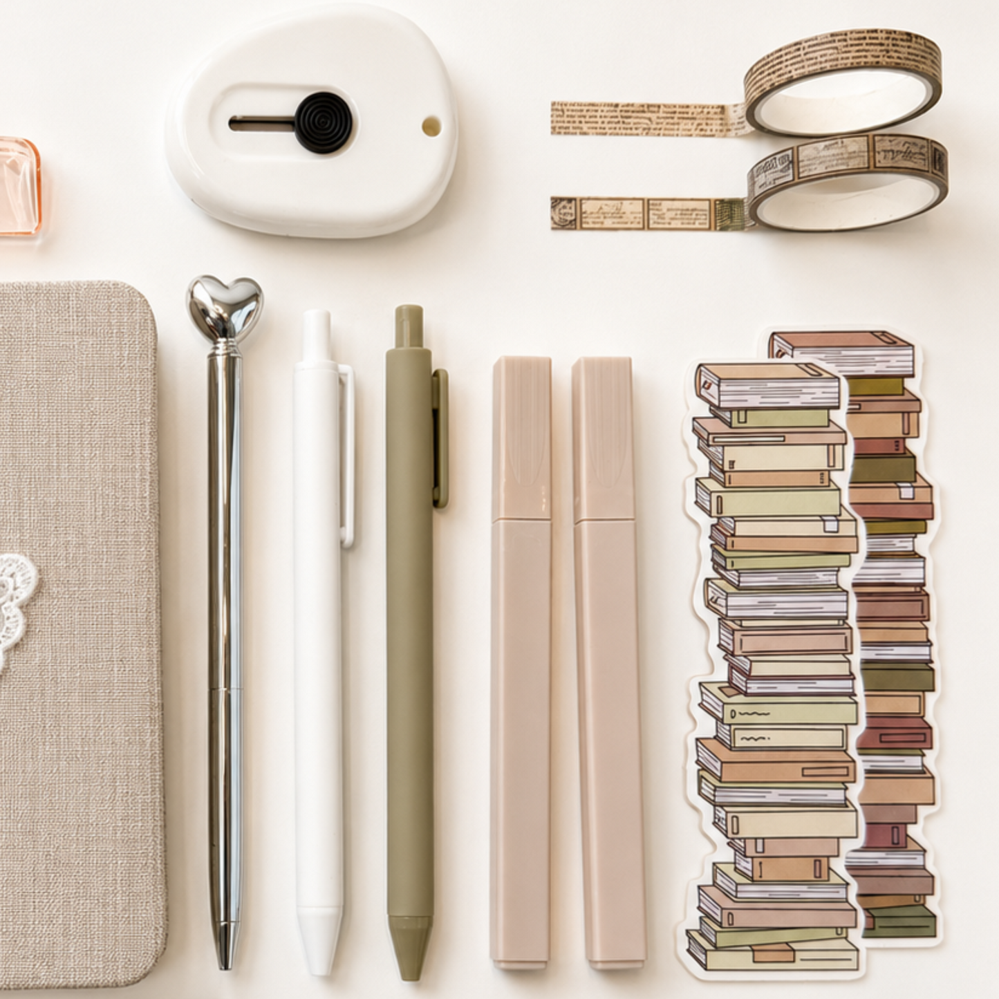 Neutral aesthetic stationery accessories with minimalist pens, washi tape, mini label maker and stacked book sticker