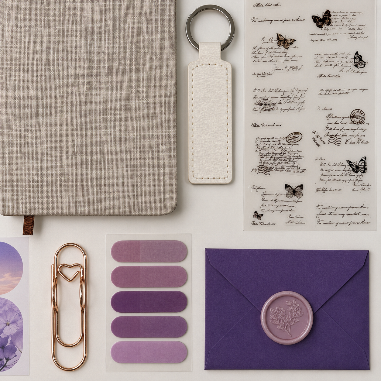Collection of stationery items including a notebook, keychain, stickers, and an envelope on a white background.