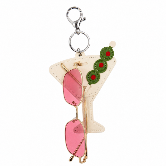 Keychain shaped like a martini glass with pink olive and green olives on a white background