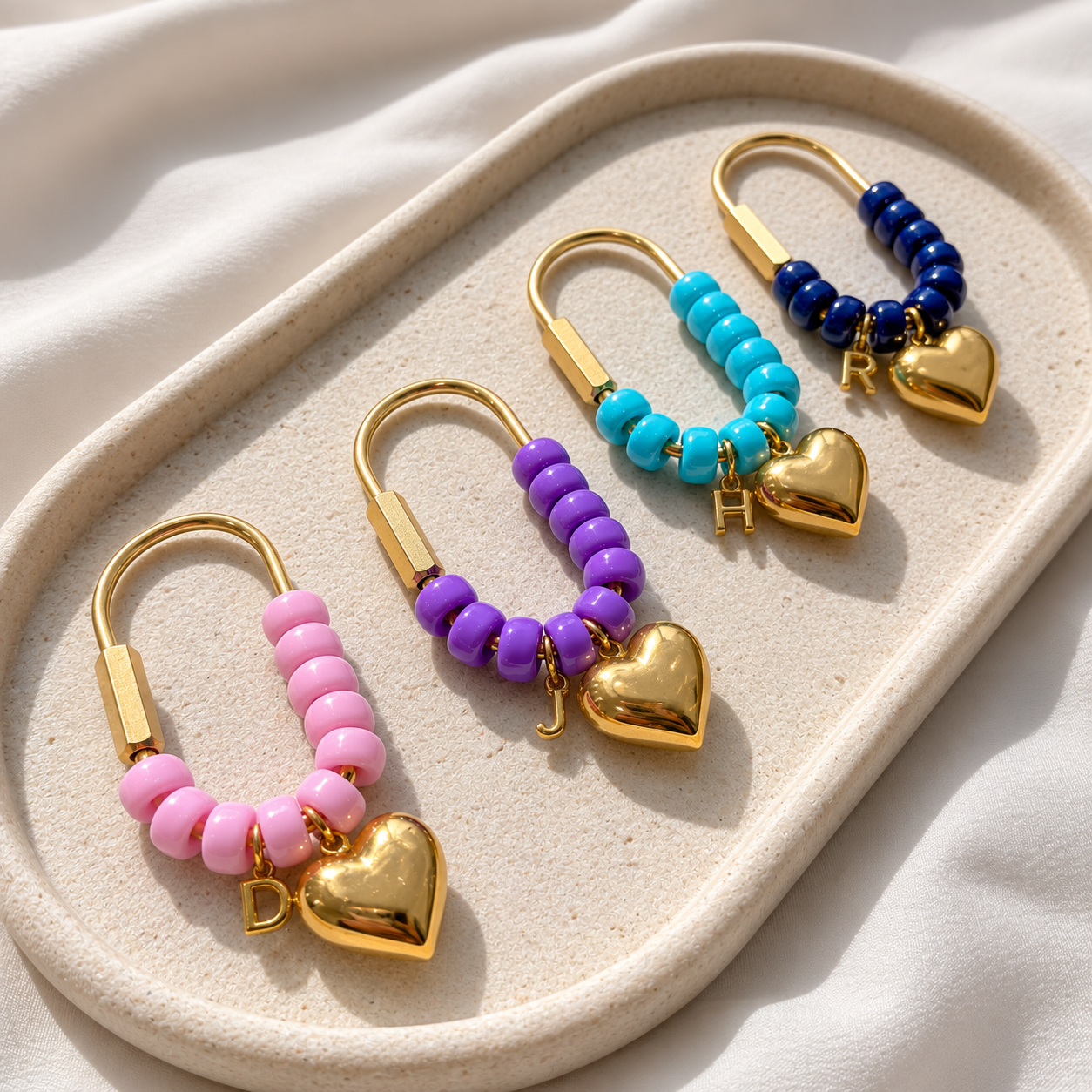 Set of colorful beaded earrings with gold hearts on a beige tray.