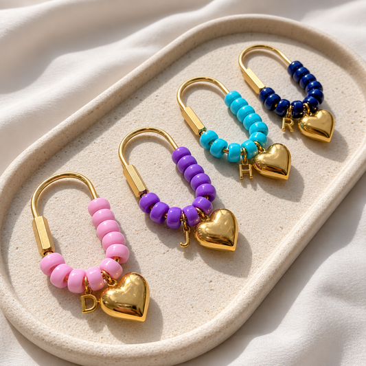 Set of colorful beaded earrings with gold hearts on a beige tray.