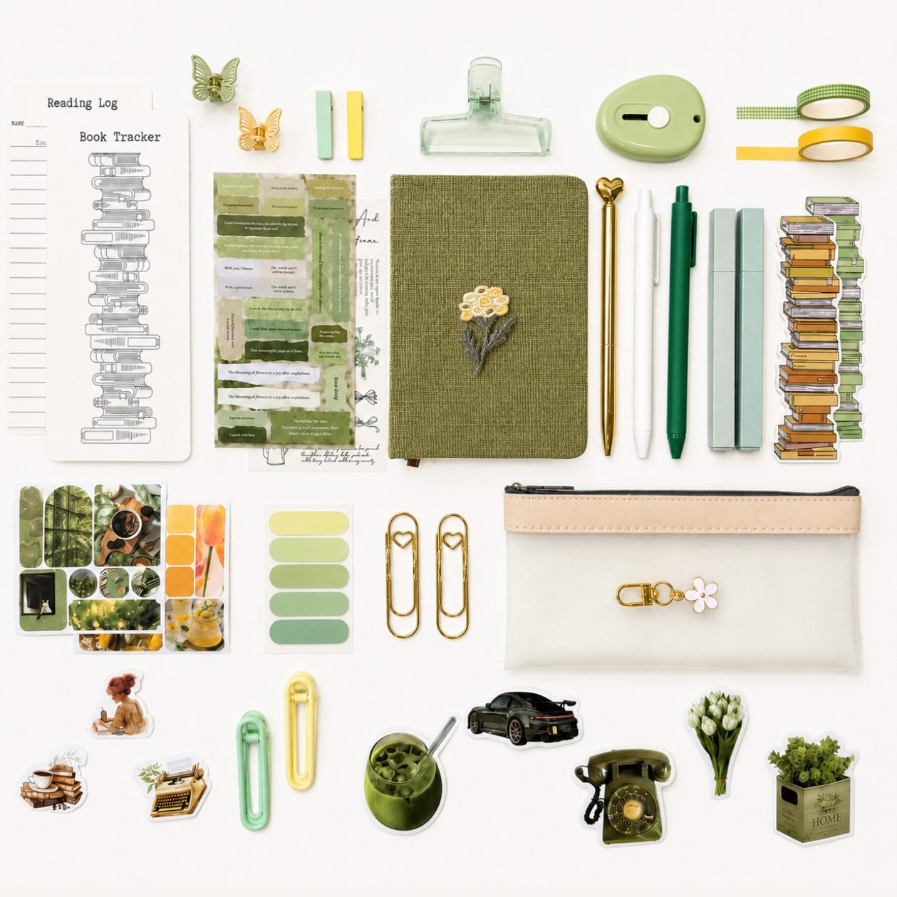 Collection of stationery items including a notebook, pens, clips, and decorative elements on a white background.