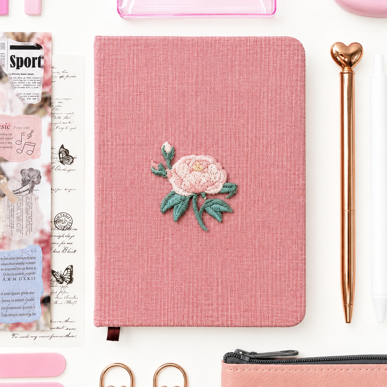 Pink notebook with floral design on a white background