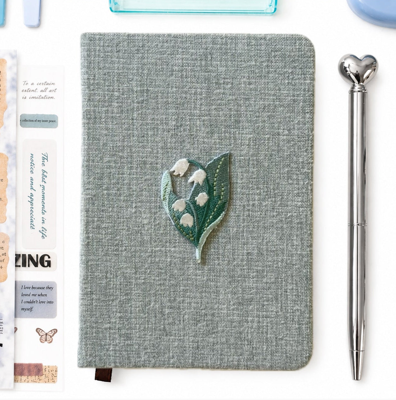 Light blue linen notebook with lily of the valley embroidery and silver heart pen