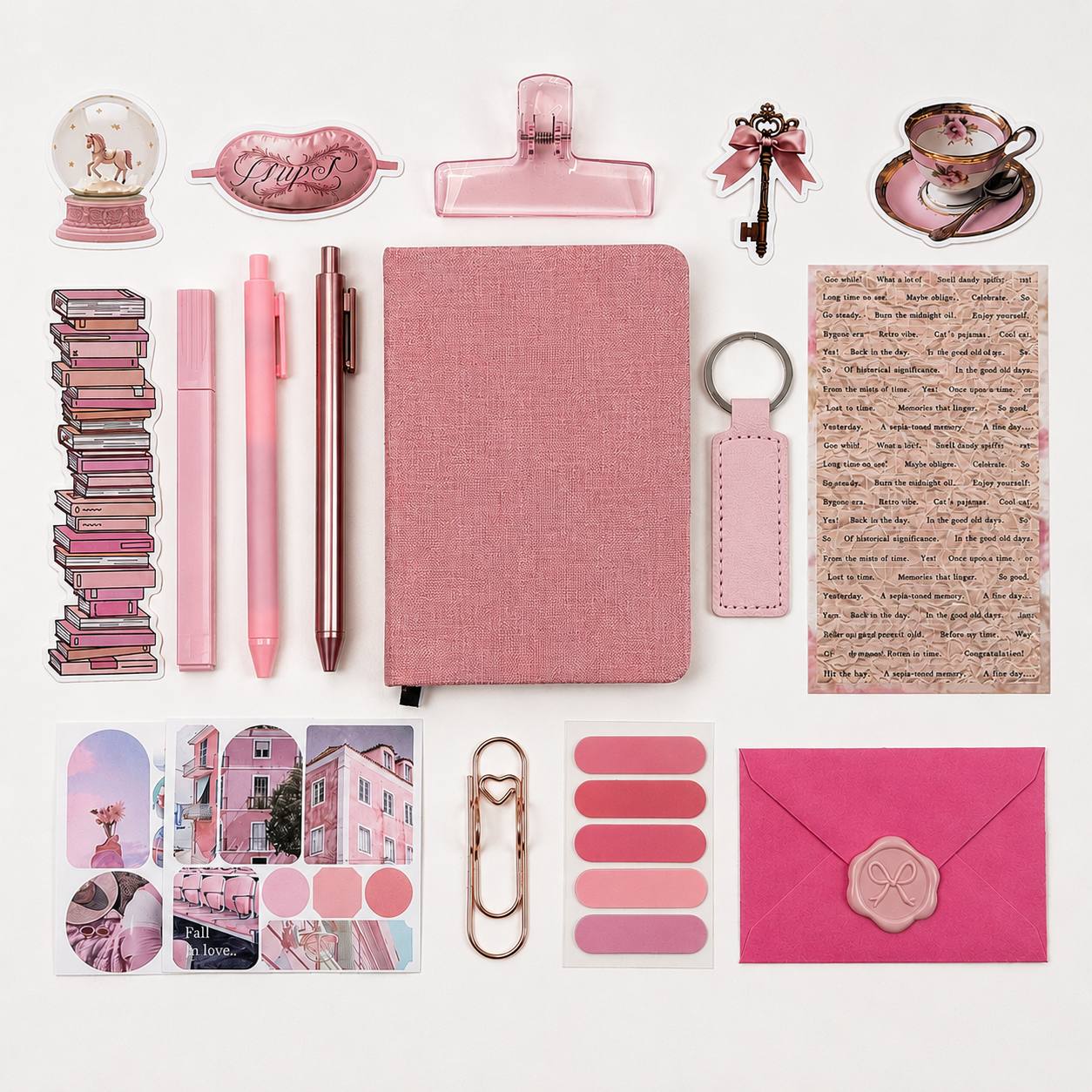 Collection of pink stationery items including a notebook, pens, clips, and keychain on a white background.