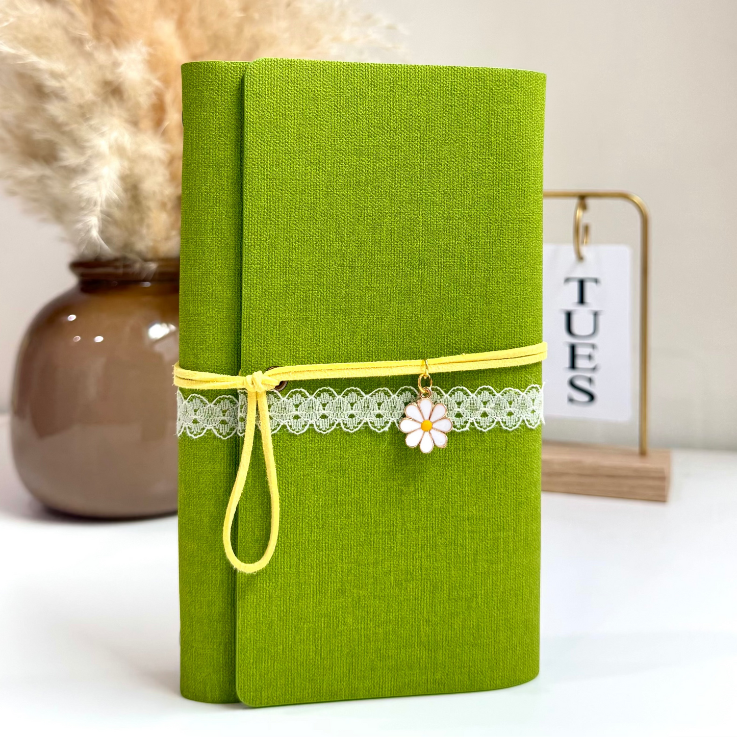 Green notebook with decorative elements on a white surface