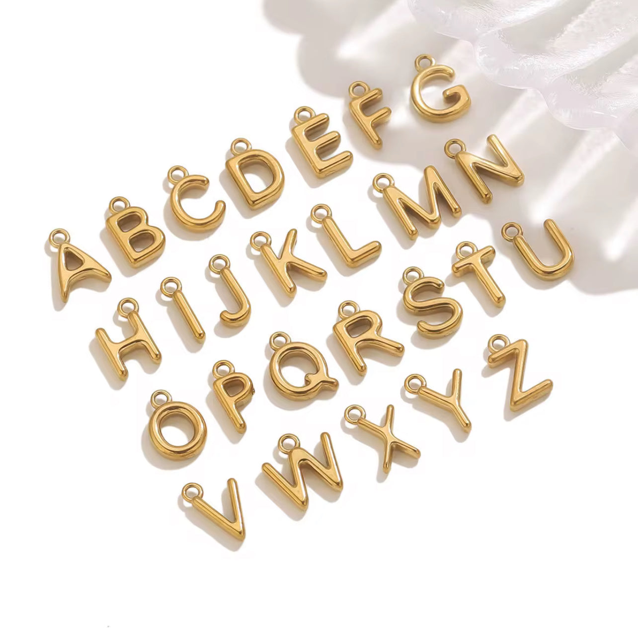 Gold letter charms on a white background